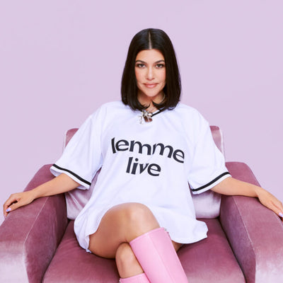 Kourtney sitting on a couch wearing a lemme live shirt