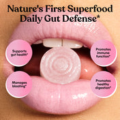 Gummy supplement in someone's mouth, labeled 'Nature's First Superfood Daily Gut Defense' and the products' benefits.