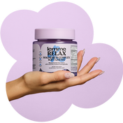 Hand holding a jar of 'lemme RELAX' magnesium complex soft chews against a purple background