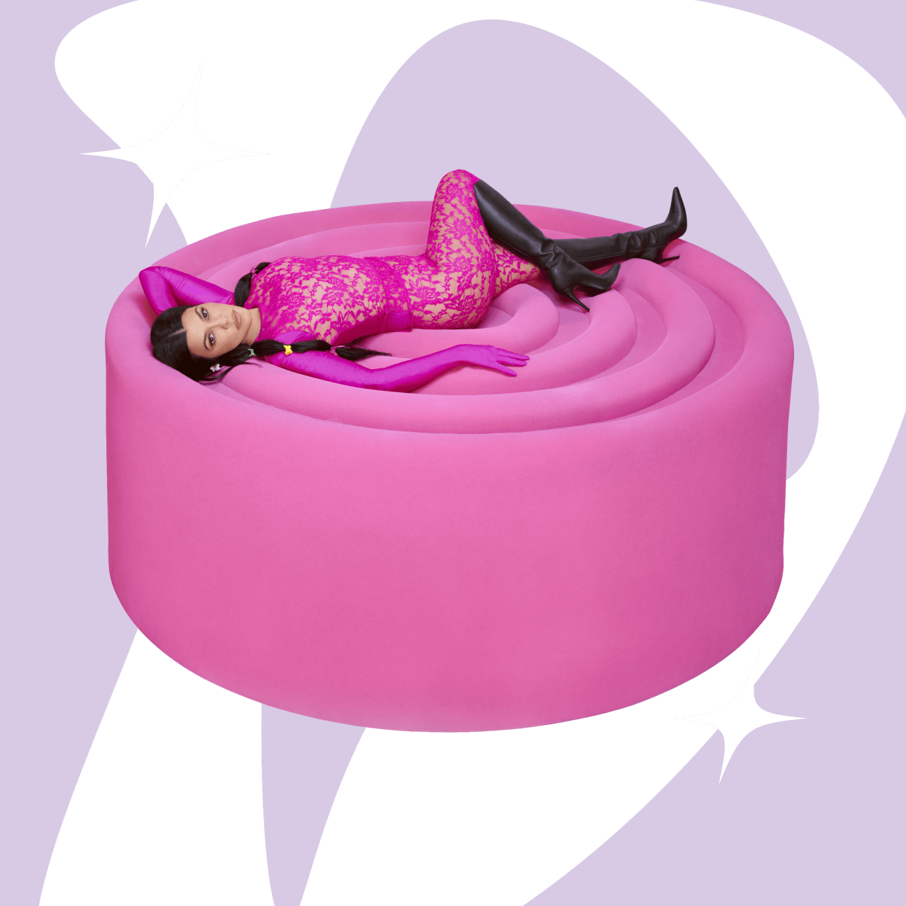 Kourtney laying on top of an oversized pink gummy with lemme debloat shape in the background